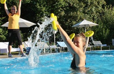 Zwei Frauen machen Wassergymnastik im Pool