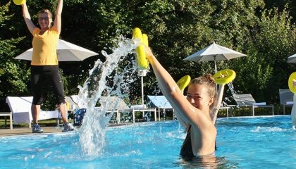 Zwei Frauen machen Wassergymnastik im Pool