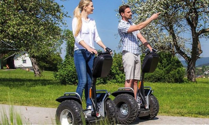 Paar fährt auf Segway durch die Natur