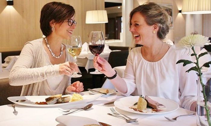 Zwei Frauen speisen und trinken Wein