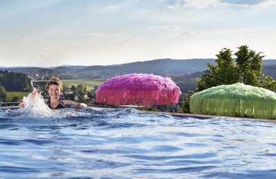 Frau schwimmt im Dachpool