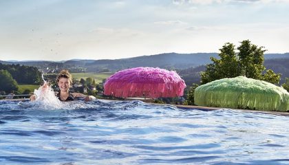 Frau schwimmt im Dachpool