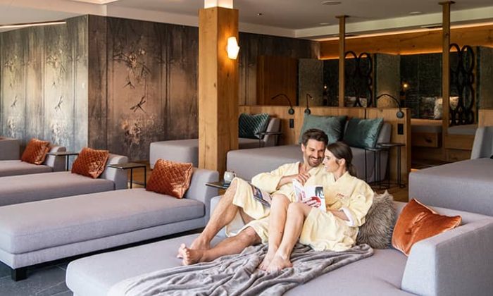 Paar in hellen Bademänteln entspannt im Ruheraum