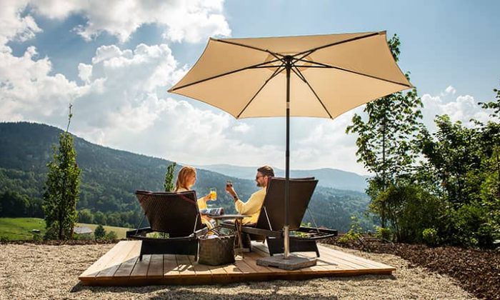 Paar entspannt im Garten unter Sonnenschirm