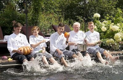 Küchenteam sitz gemeinsam am Pool mit Füßen im Wasser