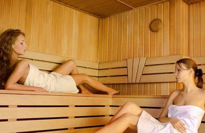 Zwei Frauen in weißen Handtüchern erholen sich in der Sauna