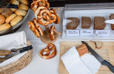 Frühstücksbuffet mit verschiedenen Brotsorten und Brezeln