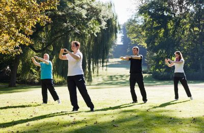 Menschen machen zusammen Sport im Garten