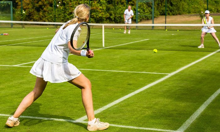 Menschen spielen Tennis auf einem Rasenplatz