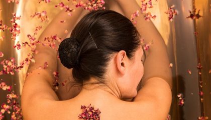Frau genießt Massage mit Blüten