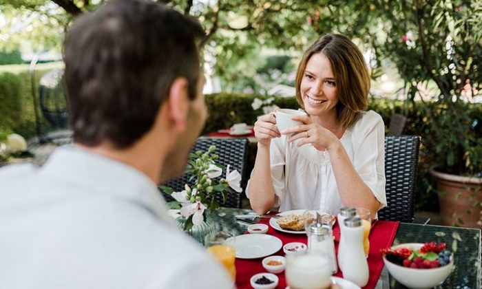 Paar frühstückt im Garten vom Hotel Antoniushof