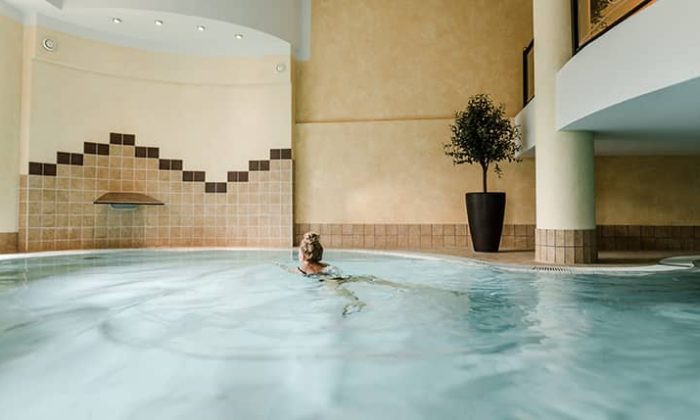 Frau schwimmt im Indoor Pool