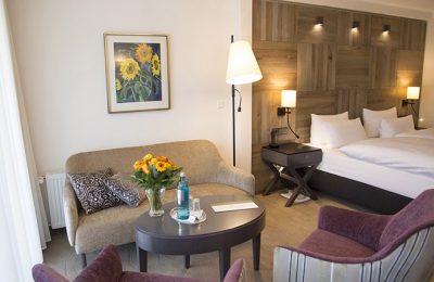 Bett und Wohnraum in der Suite Comfort