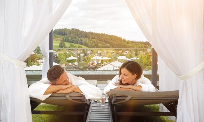 Paar entspannt auf Himmelbett im Garten