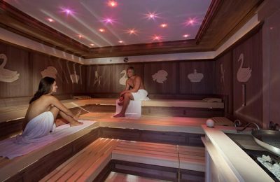 Paar schwitz in Sauna mit rosa Licht