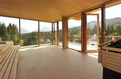 Sauna mit großer Glasfassade und Blick auf umliegenden Wald