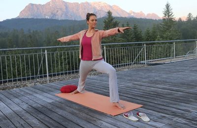 Frau macht Yoga auf einer Terrasse