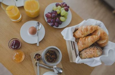 Gedeckter Frühstückstisch mit Kaffee, Orangensaft und Croissants