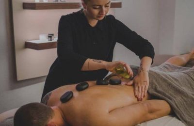 Mann genießt eine Hot Stone Massage