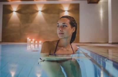 Frau kühlt sich im Pool ab