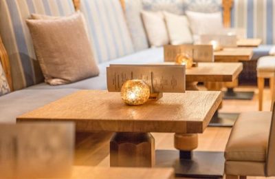 Holztische mit Kerzen an der Bar