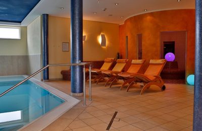 Mehrere Liegen neben dem Indoor Pool