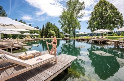 Frau steigt aus dem Naturbadesee