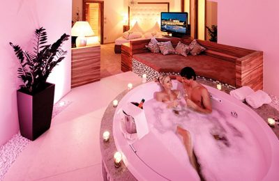 Paar badet in rosa leuchtender Badewanne
