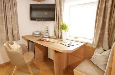 Schreibtisch und Fernseher im Einzelzimmer