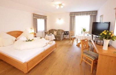 Bett und Wohnraum im Doppelzimmer