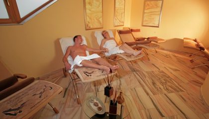 Paar entspannt auf zwei Liegen im Ruheraum