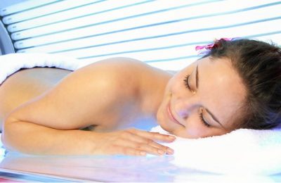 Frau sonnt sich im Solarium