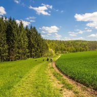 Menschen spazieren durch Wiesen und Wälder der Rhön