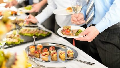 Menschen bedienen sich am Buffet