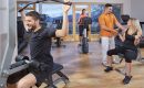 Menschen trainieren an modernen Geräten im Fitnessraum