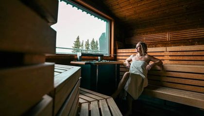 Frau genießt einen Saunagang mit Blockhaussauna