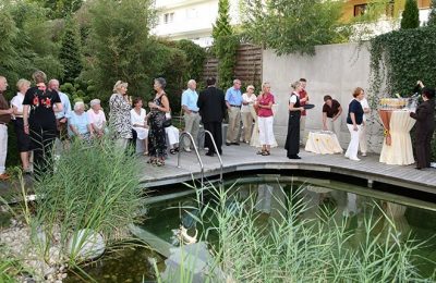 Gruppe Menschen stoßen an am Naturschwimmbad