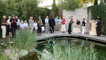 Gruppe Menschen stoßen an am Naturschwimmbad