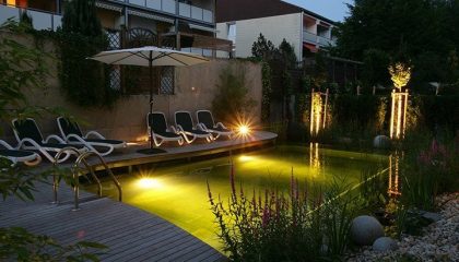 Beleuchtetes Naturschwimmbad am Abend
