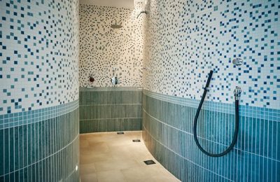 Duschen im weiß-blau gefliesteb Saunabereich