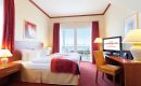 Bett und Wohnraum in der Turmsuite mit Blick aufs Meer