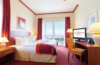 Bett und Wohnraum in der Turmsuite mit Blick aufs Meer