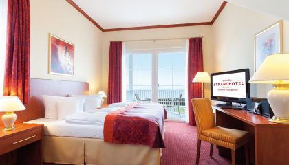 Bett und Wohnraum in der Turmsuite mit Blick aufs Meer