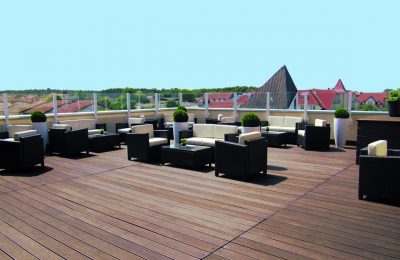 Zahlreiche Sitz- und Ecksofas auf der Dachterrasse vor blauem Himmel