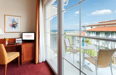 Tisch und Stuhl vor Balkon mit Meerblick im Doppelzimmer