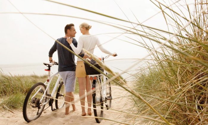 Paar mit Fahrrädern in den Dünen von Sylt