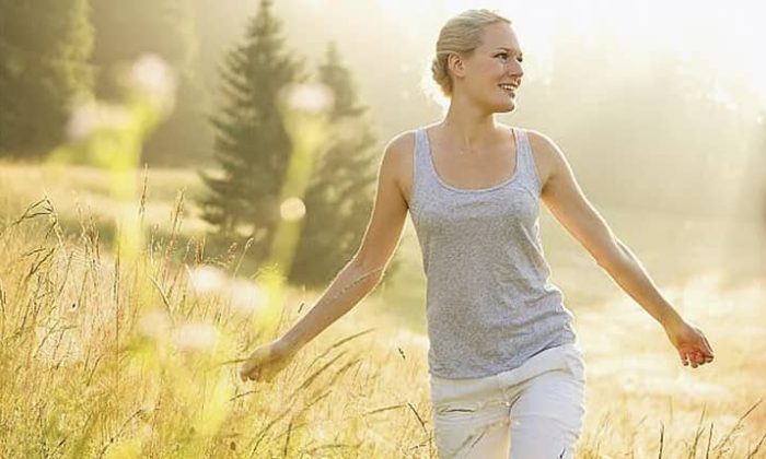 Frau spaziert über Wiese