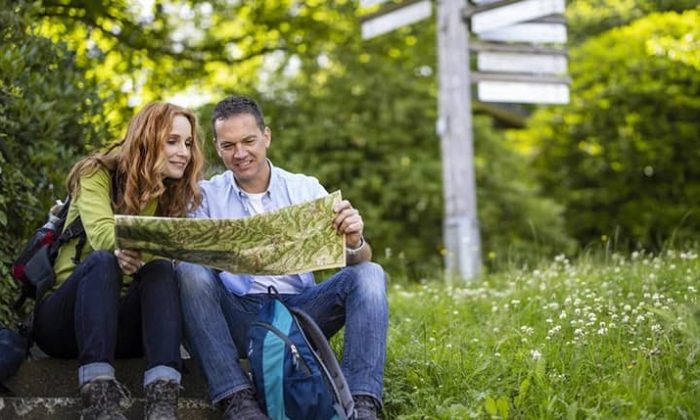 Paar schaut beim Wandern auf eine Wanderkarte