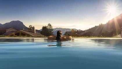 Frau blickt aus Pool in die Ferne