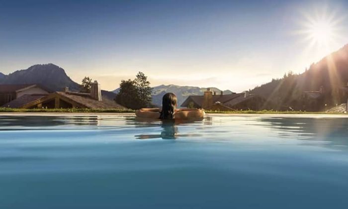 Frau blickt aus Pool in die Ferne